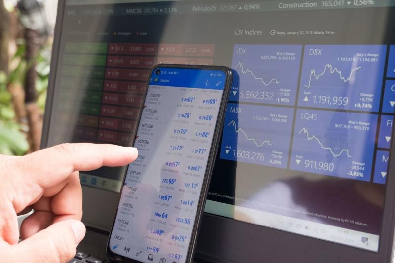 Advisor reviewing market data on a phone and laptop